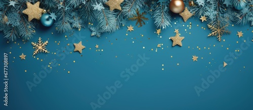 Christmas arrangement featuring pine twigs gold and blue ornaments confetti on blue backdrop From above flat lay Xmas mockup vintage postcard Copy space image Place for adding text or design