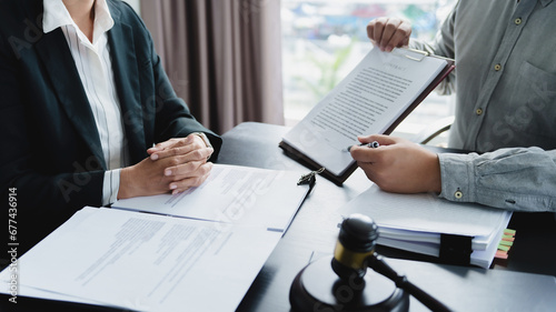  Labor law concept. Lawyer signing legal document with Judges gavel..