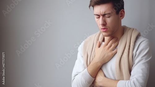 The young man has his hand on his chest and is in pain. Symptoms of a cold or flu. Chest pain, cough