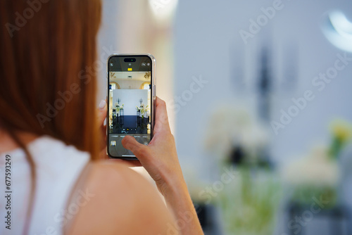 A girl takes a photo on her phone. Photo zone in the wedding banquet hal