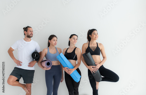 A group of female and male athletes stood and chatted amicably in the studio before beginning with the yoga class.