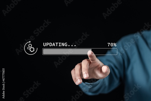 Hand touching downloading progress bar and installing update process. Software updates or operating system upgrades to keep your device up to date with enhanced functionality in new versions.