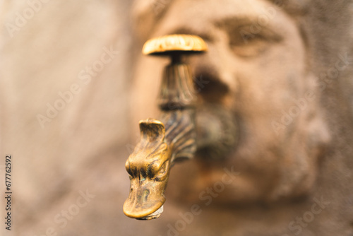 goldener Wasserhahn an einem Brunnen in der italienischen Stadt Chiavenna