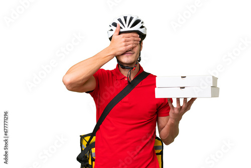 Pizza delivery man with work uniform picking up pizza boxes over isolated background covering eyes by hands. Do not want to see something