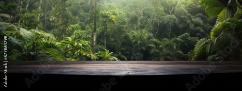 burnt wood table for product presentation. against the background of palm trees and various tropical jungle plants