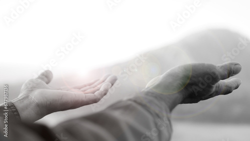 Hands receive lights in black and white background. Hand reaching out. Hope and faith, spiritual backgrounds concept. Receiving blessings. Surrender to God concepts.