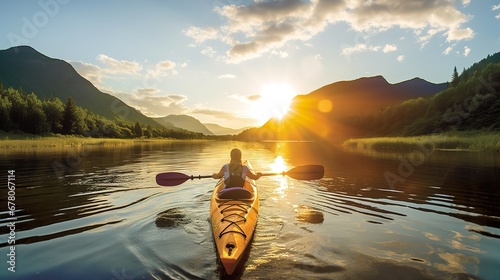 A woman with paddles on a kayak in a crystal lake against a background of majestic mountains.