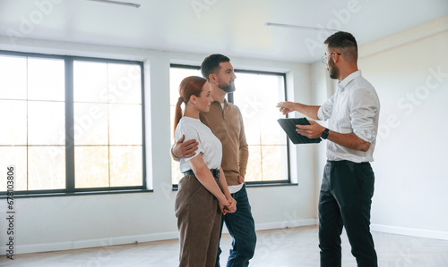 Brand new apartment. Realtor shows a room to a young couple