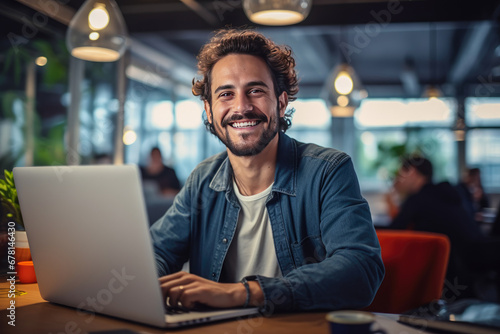 Portrait of attractive smiling man sitting in office and looking at camera..