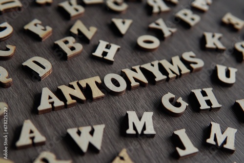 Closeup image of text ANTONYMS surrounded by scattered alphabet.