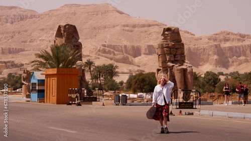 Woman tourist in Colossi of Memnon in Luxor Egypt