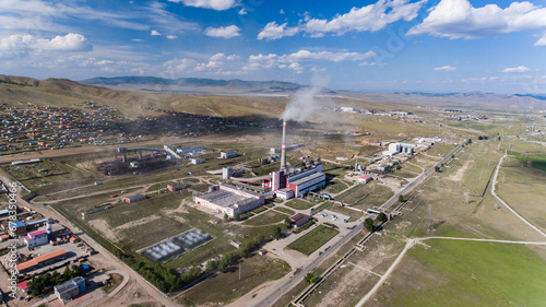 Factory smokestacks towering over a Mongolian town