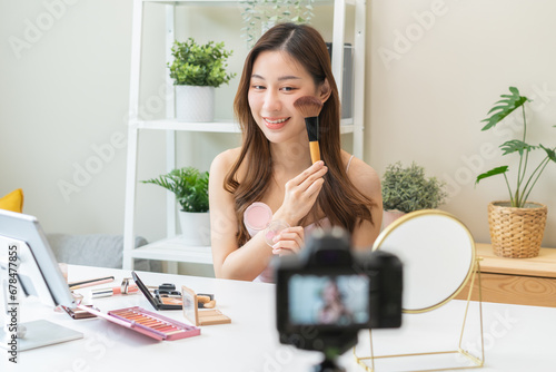 Beauty blogger, asian young woman, girl vlogger makeup face, showing, reviews cosmetics products while recording video, tutorial to share on social media. Business online influencer on camera.