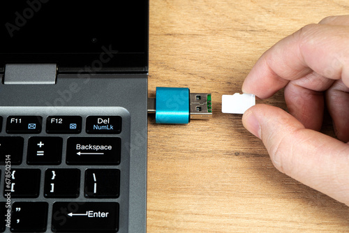 usb flash drive adapter micro sd card connection to laptop. micro sd card in man's hand