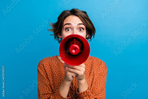 Photo portrait of lovely young lady hold megaphone announce sale wear trendy brown garment isolated on blue color background