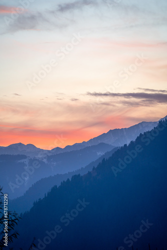 Pink blue hues of himalaya mountains fading off into fog showing the serene view from Manali Kullu vacation destination for winters and summers