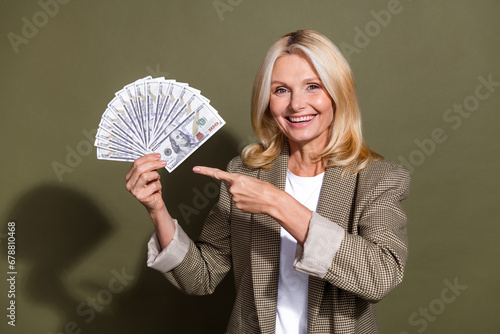 Photo of happy millionaire business lady point finger banknotes easy money profitable investment method isolated on khaki color background
