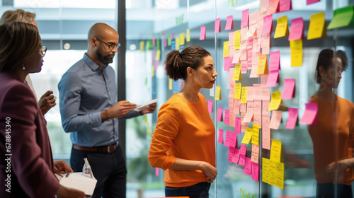 A professional team engaged in a brainstorming session, using colorful sticky notes on a glass wall to organize their ideas and strategies.