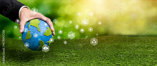 Businessman holding Earth with eco friendly icon design symbolize business company commitment to protect planet Earth's ecosystem with net zero technology and ESG practice. Panorama Reliance