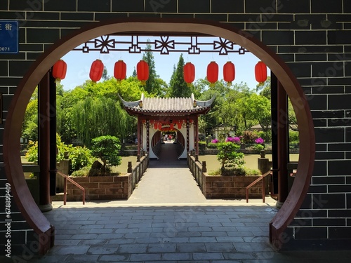 Moon gate in a beautiful Chinese garden with green vegetation