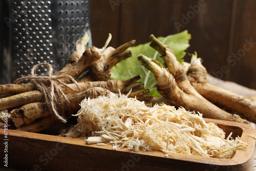 Grated horseradish and roots on table, closeup