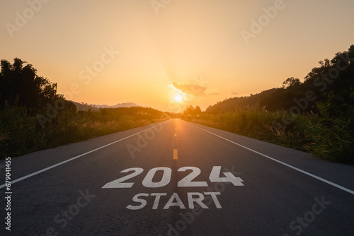 Happy new year 2024,2024 symbolizes the start of the new year. The letter start new year 2024 on the road in the nature route roadway sunset tree environment ecology or greenery wallpaper concept.