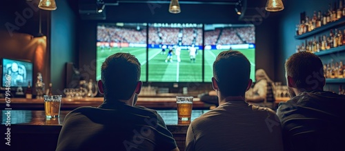 Friends in sports bar watching game on screens from behind Copy space image Place for adding text or design