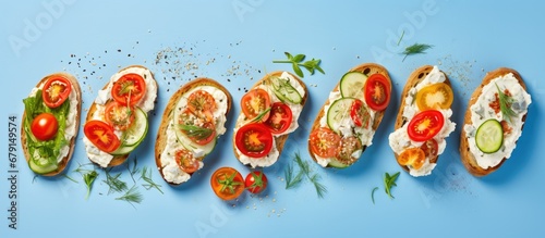 Healthy eating concept variety of open faced sandwiches on rye bread with cream cheese ricotta cherry tomatoes red pepper cucumber slices and dry herbs Copy space image Place for adding text or