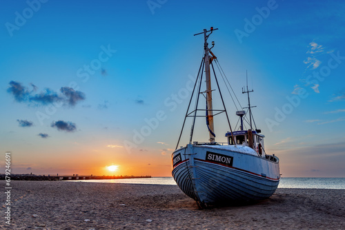 Fishing boats on the beach at sunset in Vorupor, Denmark.
