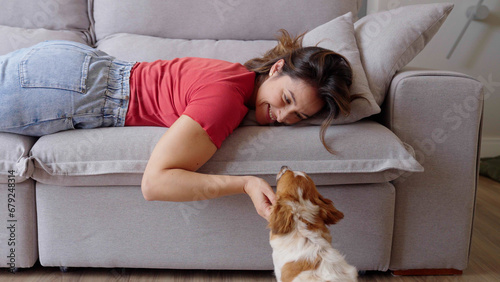 Portrait of a Woman laying on a Couch, Petting her Dog and Spending Time Bonding with Him. Lovely Cute Moment Shared Between Owner and Lovely mixed breed dog, Caressing and Kissing 