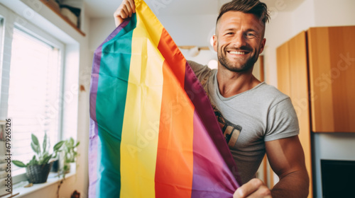 smiling gay men with gay pride flag at home