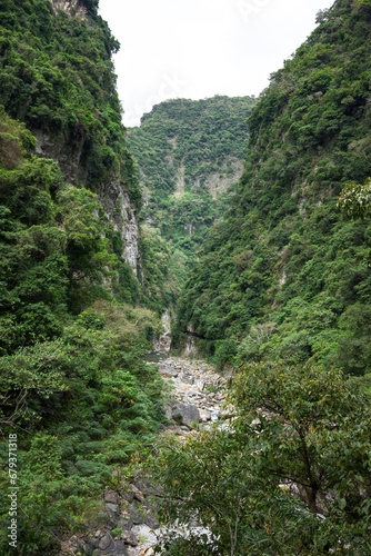 Lush greenery clings to steep cliffs, framing a hidden river valley that whispers tales of ancient geological forces and the quiet power of nature.