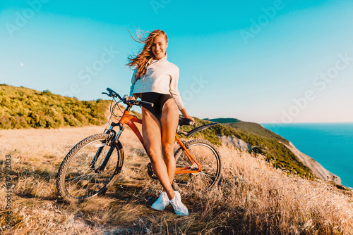 Attractive woman with mountain bicycle in outdoor. Lifestyle with young lady