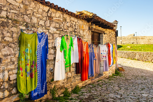 Hanging beautiful traditional dresses different colors and decoration at market, bazaar, fashion in old city of Albania