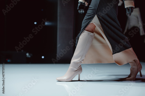 Black long skirt and beige high heels. Fashion model walking runway fashion show