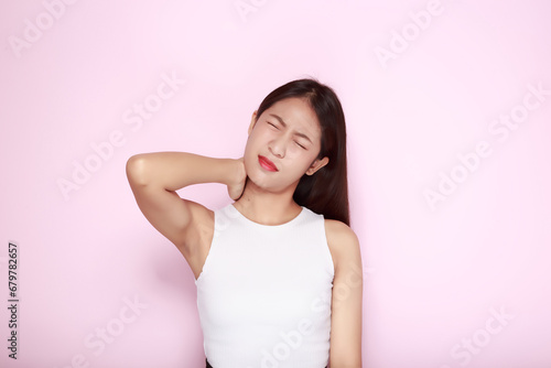 Portrait of a young woman in a light pink background, Asian woman experiencing pain in her body.