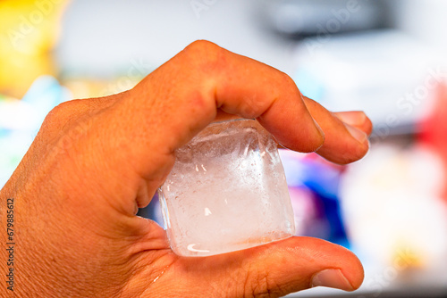  fingers an ice hand holding between the hand holding hand holding between the fingers an ice cube, solid water. the fingers an ice cube, solid water. an ice cube, solid water, solid water.