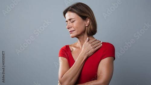 diseases and illnesses - woman with face distorted in pain holds one hand at his neck,shoulder or upper arm