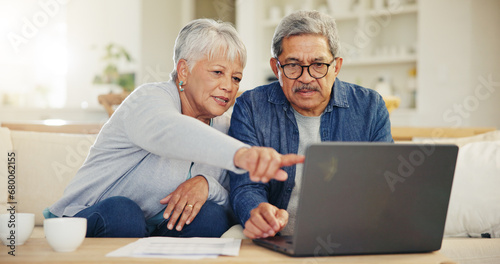 Senior, couple and planning on laptop in living room with document for finances, investment or retirement. Elderly man, woman and pointing by technology for online banking, account balance or savings