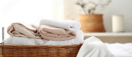 Minimalist clothing organization with neatly folded white towels and laundry in baskets on the bed inspired by the Japanese folding system Copy space image Place for adding text or design