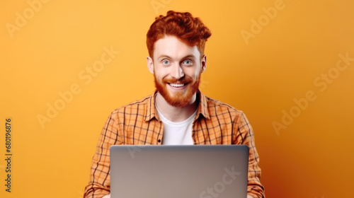 Smiling cheerful smart young ginger man wearing casual teenage clothes using laptop computer pose looking at camera isolated color background