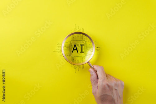 AI Artificial Intelligence technology concept. Man hand holding a magnifying glass focusing on an AI chip on yellow background. AI prompt generator, Machine learning, Marketing with robot, copy space,