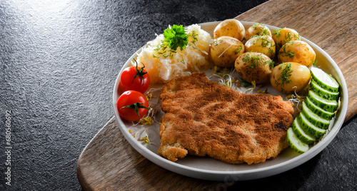 Pork cutlet coated with breadcrumbs with potatoes and cabbage