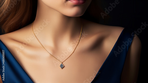 delicate golden necklace with a sapphire pendant worn by a model closeup isolated on black background