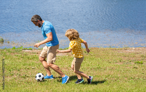 happy childhood of son playing with father. father and son summer activity. son has bonding time with father outdoor. Father and son enjoy a friendly game of football. explore the world together