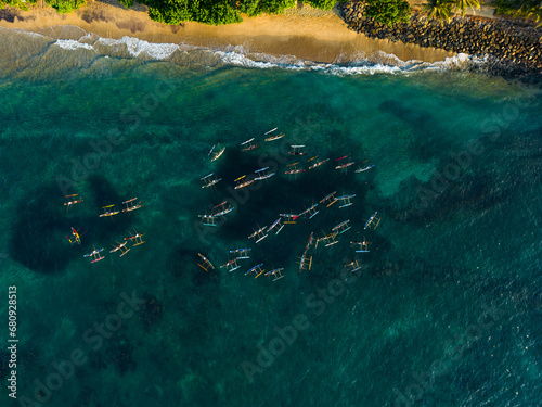 Aerial view of traditional oruwa boats as local fishermen navigate the azure waters near the coastline. Traditional fishing methods in Sri Lanka. Outrigger canoes. Top view from above. Drone shot