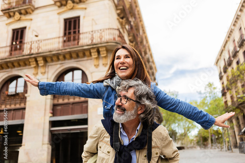 Joyful mature couple having fun together enjoying vacation on city street. Two retired older people enjoying time together during autumn holidays or weekend getaway