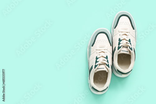 Stylish sneakers on turquoise background