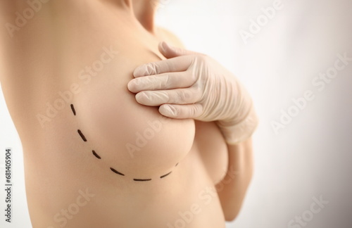 Female hand in gloves holding breast closeup on doctor mammology clinic reception. Mammary glands test biopsy implant silicone insert tumor human concept