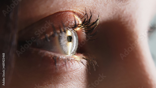 Close-up of a young woman having her vision tested on an ophthalmology diagnostic vision testing equipment. Professional ophthalmological apparatus.